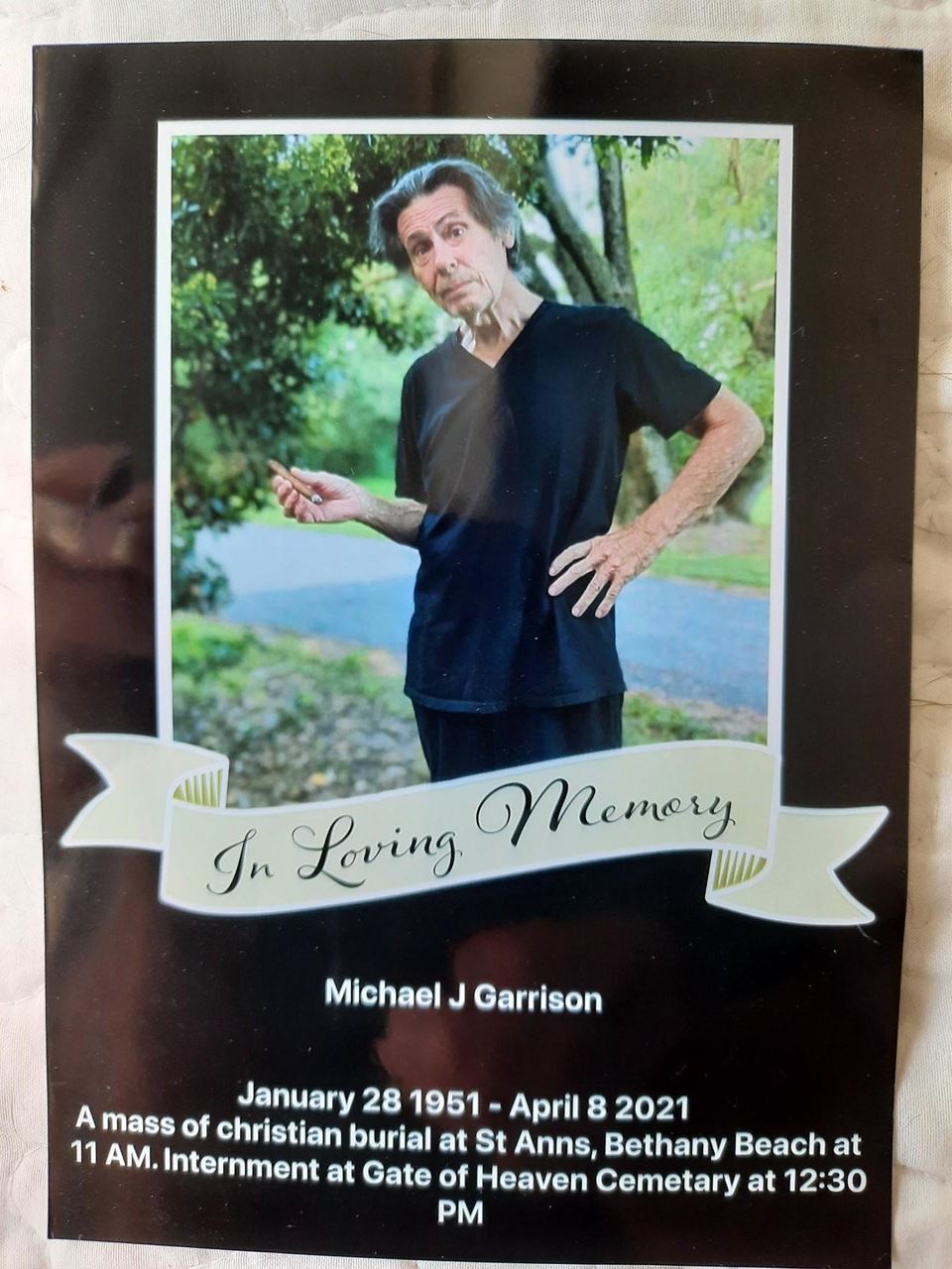 Memorial Card for Michael J Garrison. The card shows an image of Mr. Garrison and reads "In Loving Memory. Michael J Garrison. January 28, 1951 - April 8, 2021. A mass of Christian burial at St Anns, Bethany Beach at 11 AM. Internment at Gate of Heaven Cemetery at 12:30 PM."